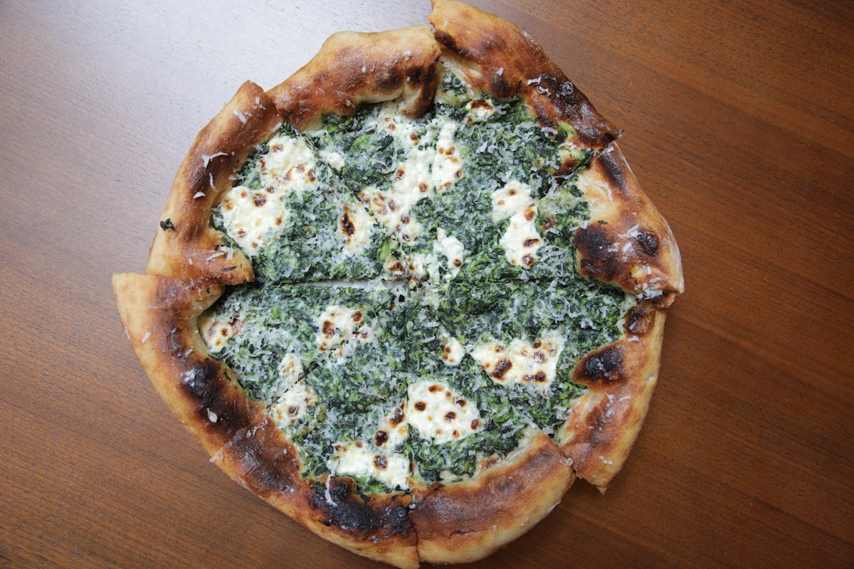 a pizza sitting on top of a wooden cutting board