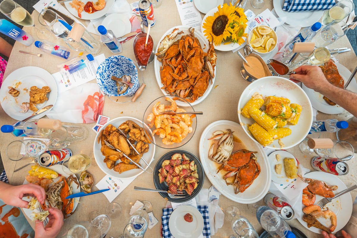 a group of people sitting at a table full of food