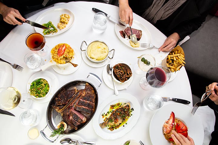 a group of people sitting at a table with a plate of food