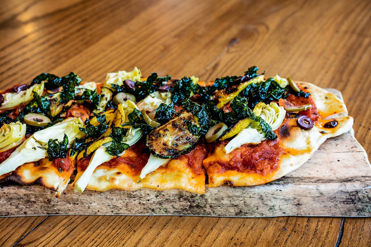 a pizza sitting on top of a wooden cutting board