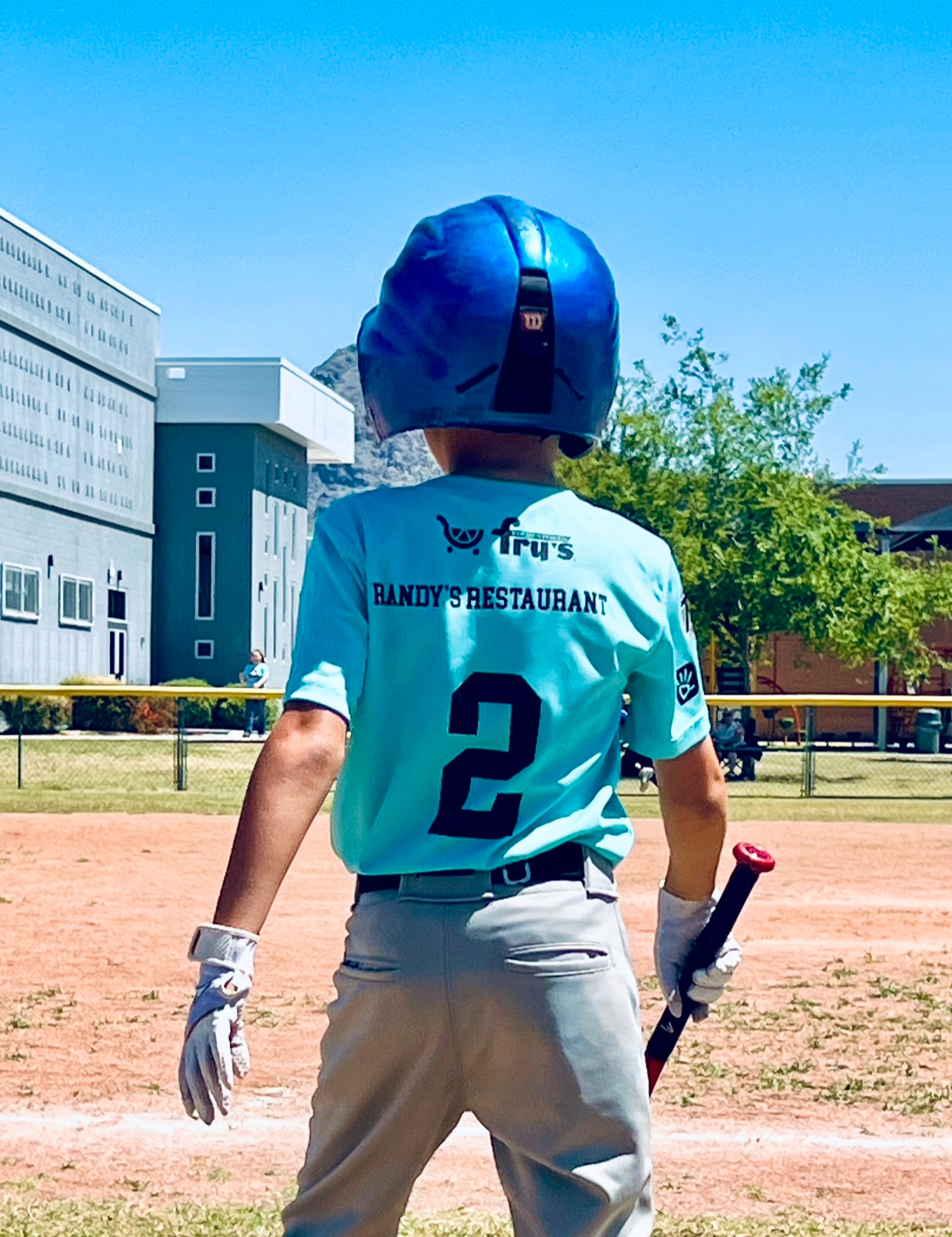 a young boy holding a baseball bat on a field