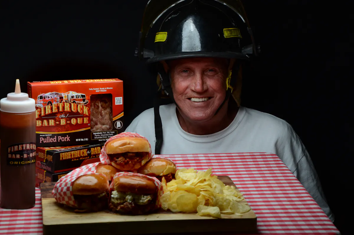 a man with a fireman's hat with three pulled pork burgers and chips 