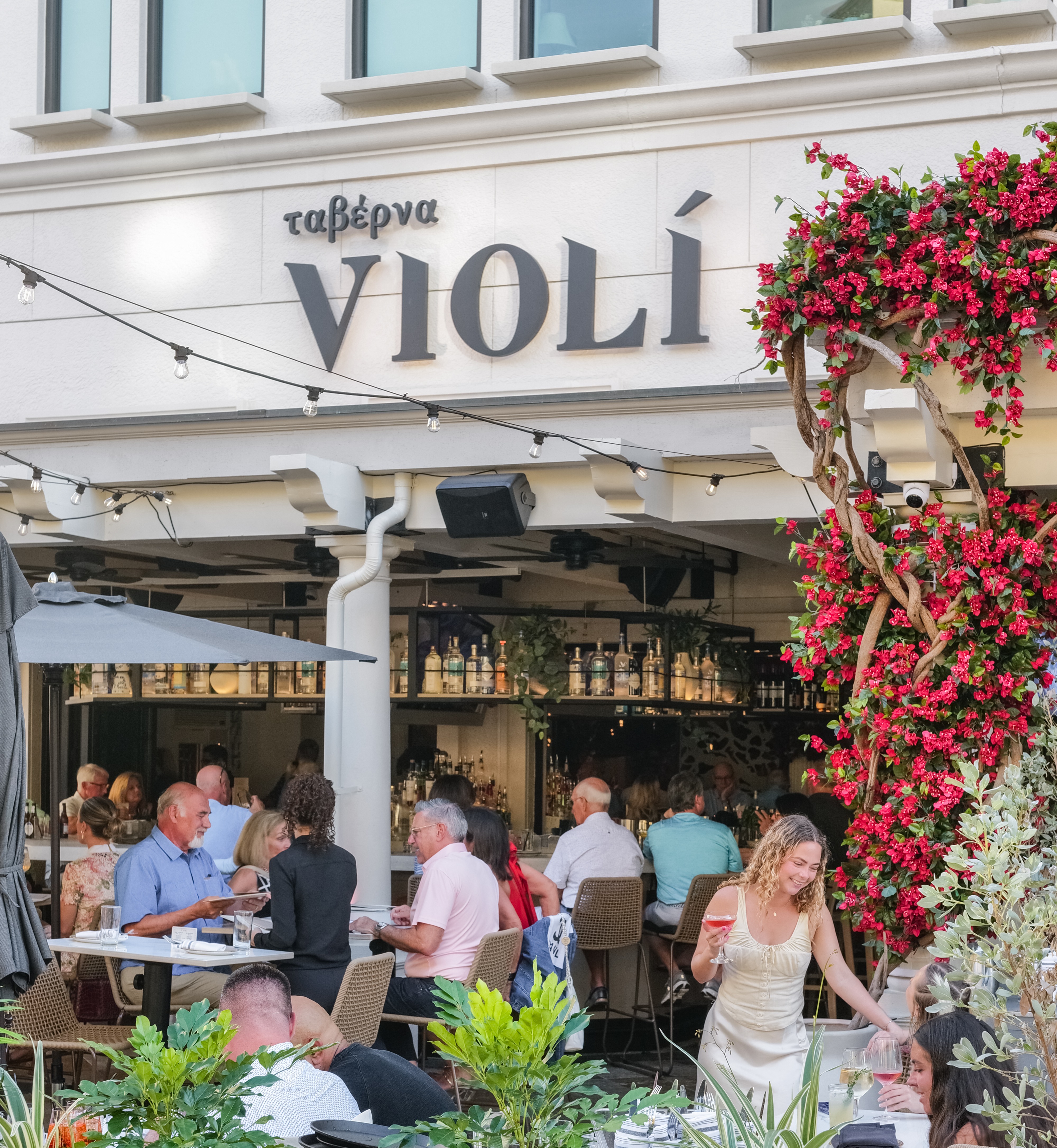 a group of people sitting at tables outside a restaurant