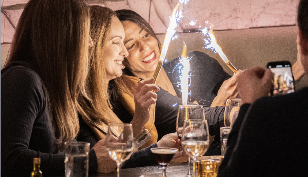 a woman sitting at a table with wine glasses