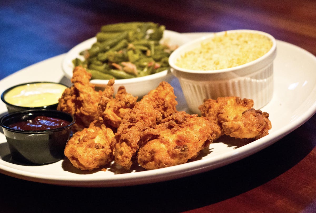 chicken fingers served with vegetables and cheese 
