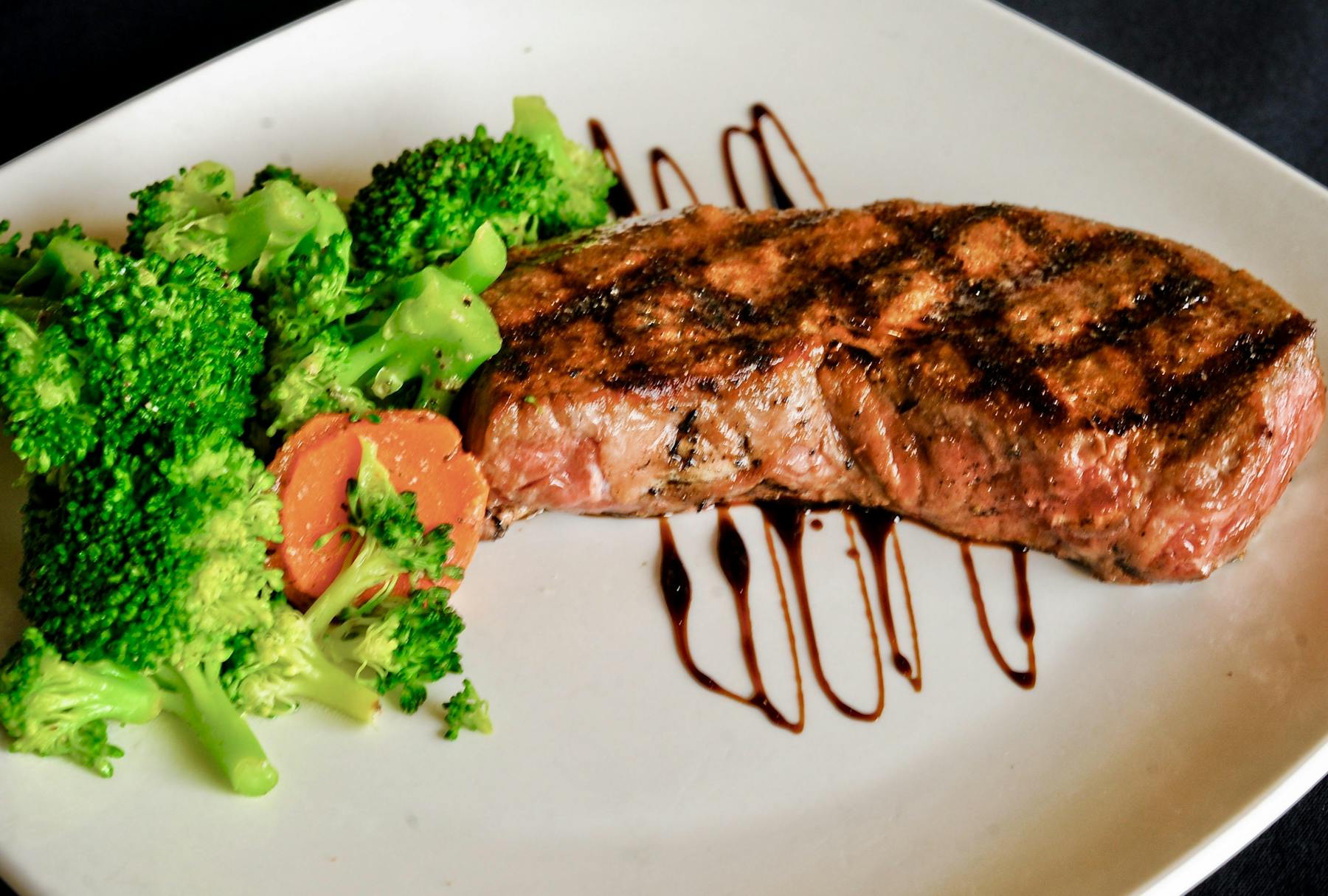 steak served with steamed broccoli and carrots
