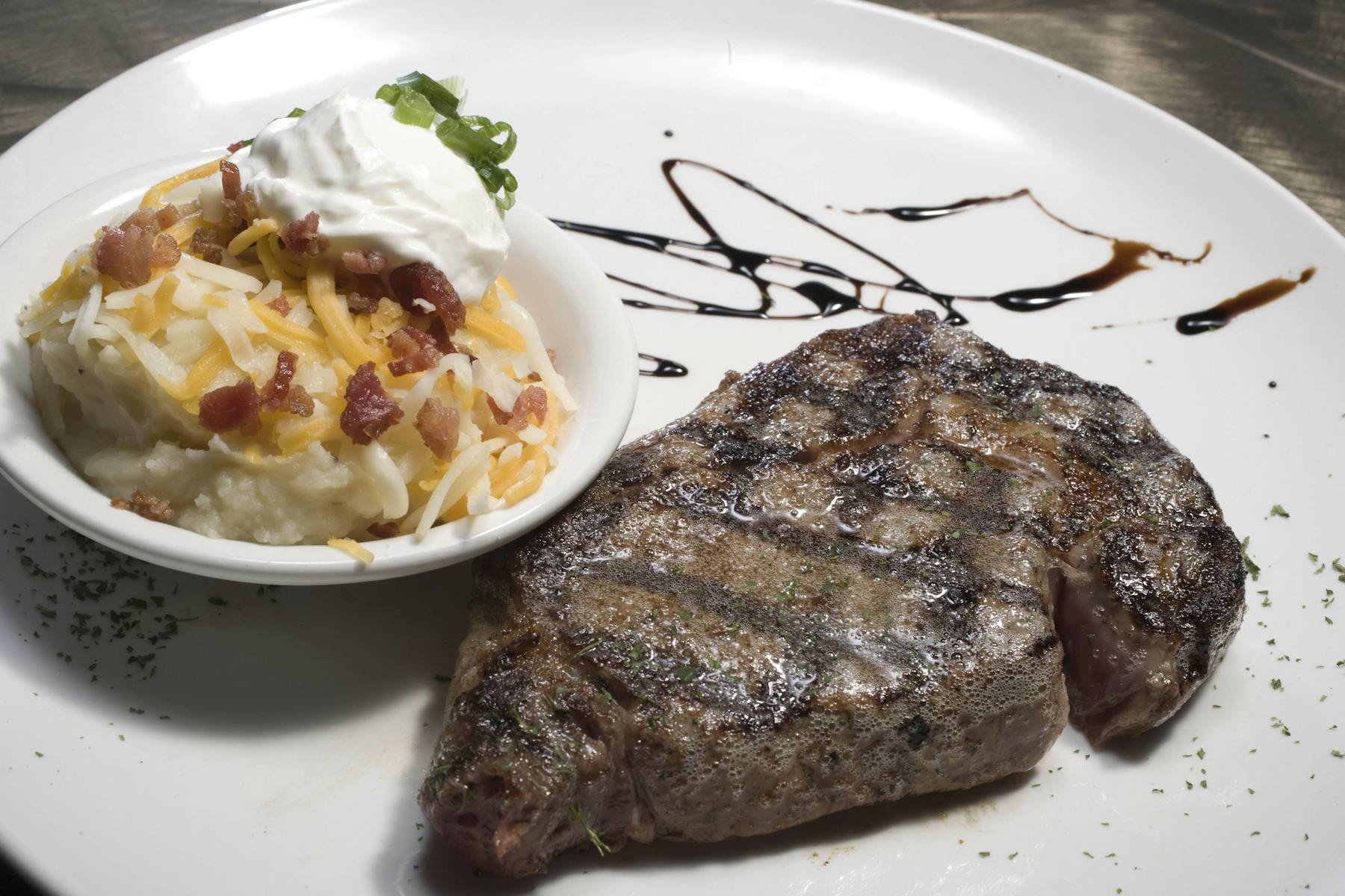 a steak served with smashed potatoes