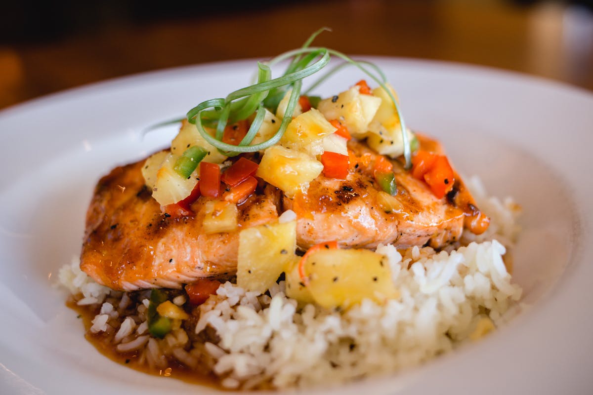 salmon served over a pile of rice 