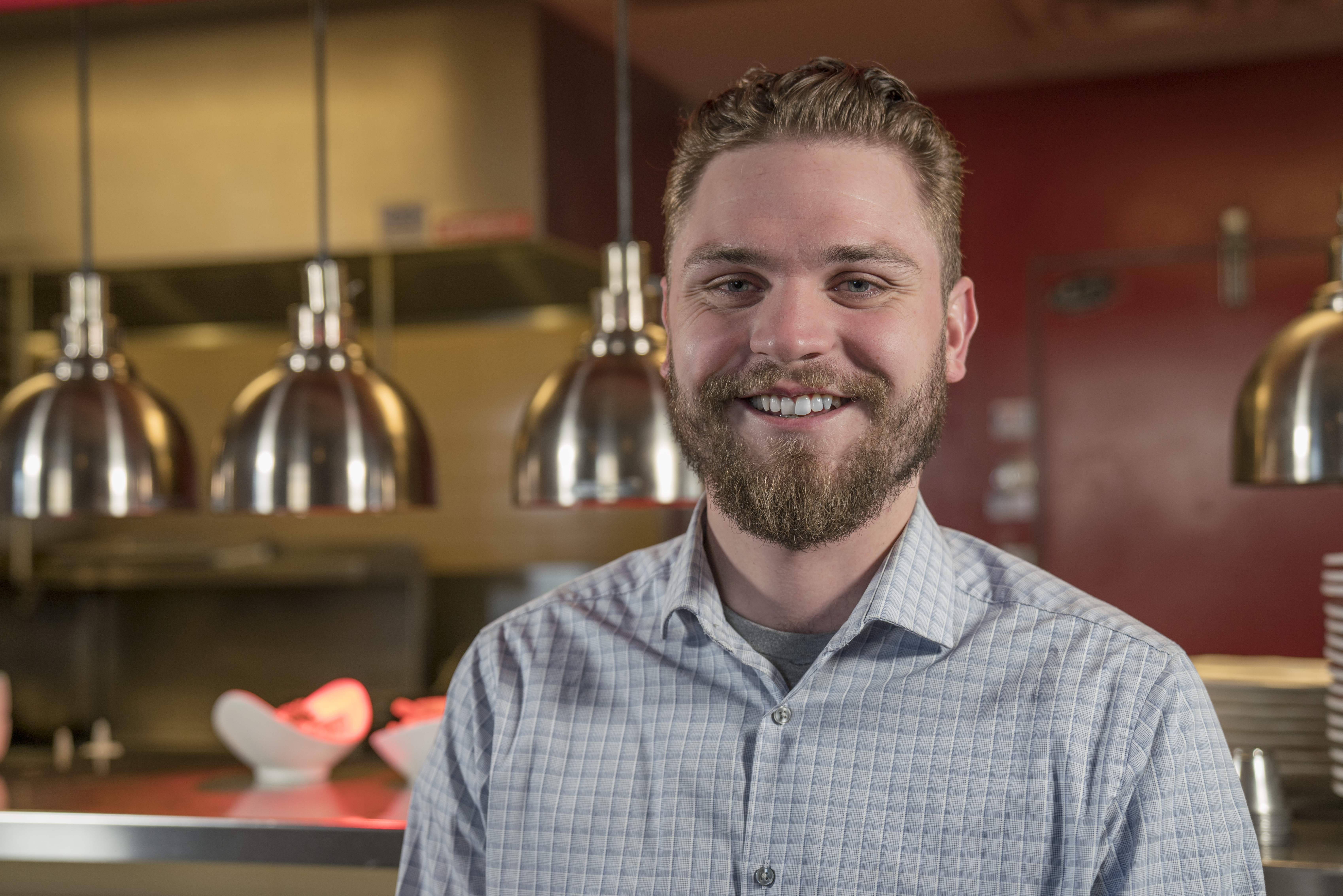 a man wearing glasses and smiling at the camera