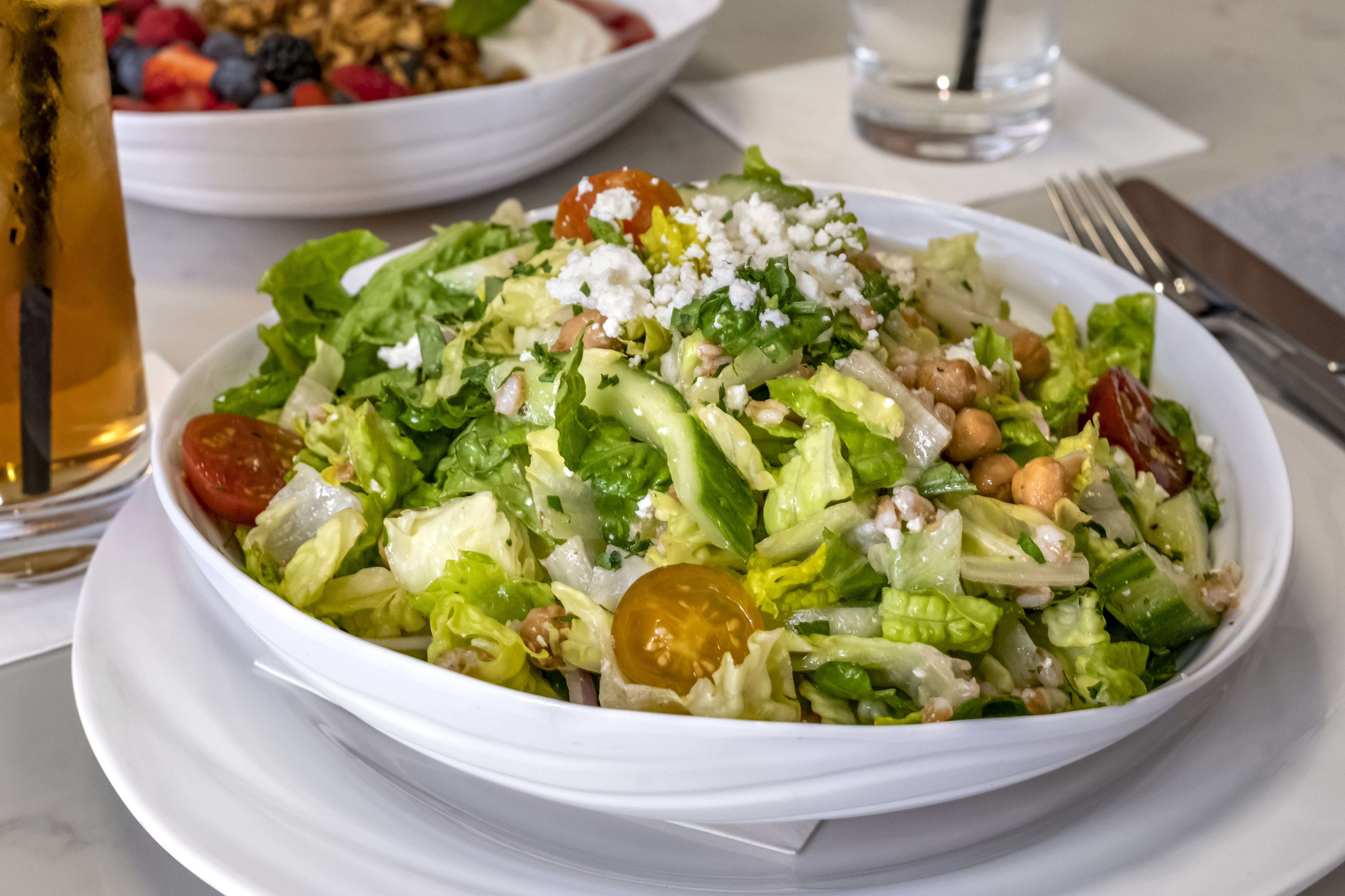 a bowl of salad on a plate on a table