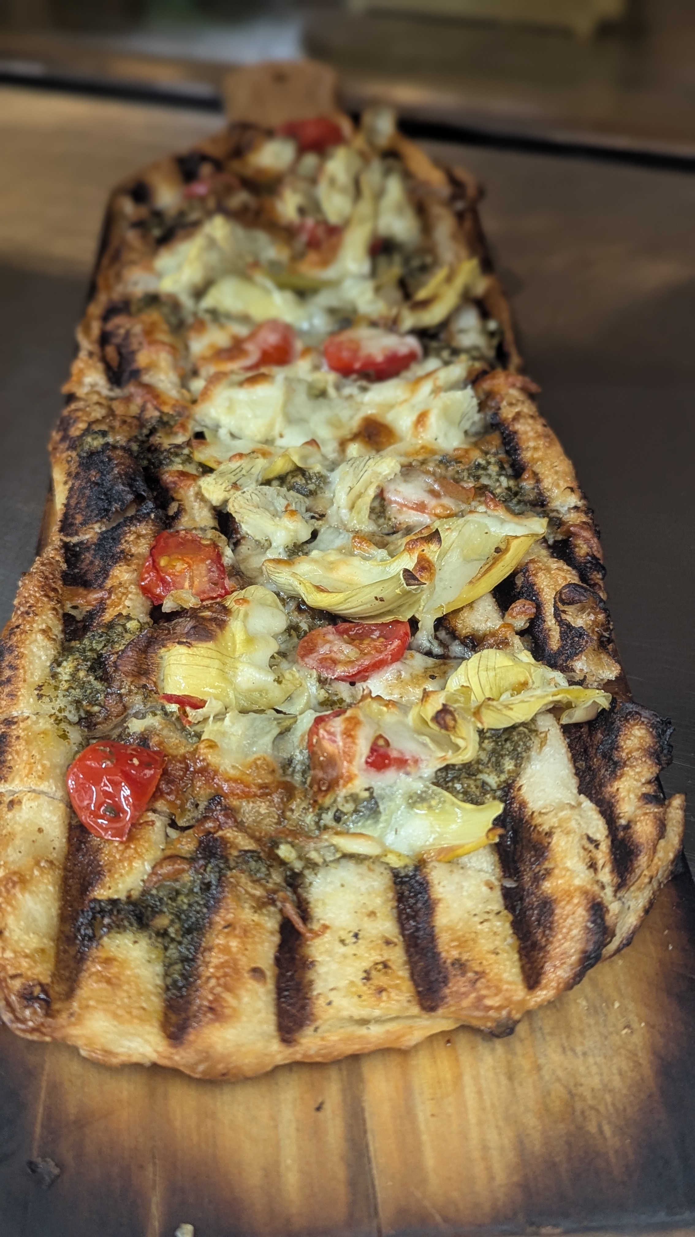a pizza sitting on top of a wooden cutting board
