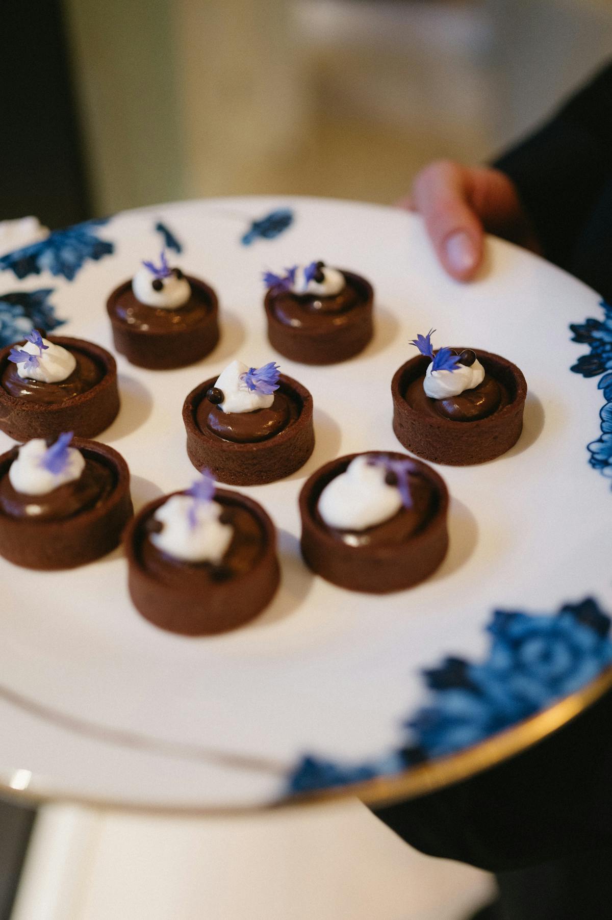 A tray of chocolate dessert being passed at an event.