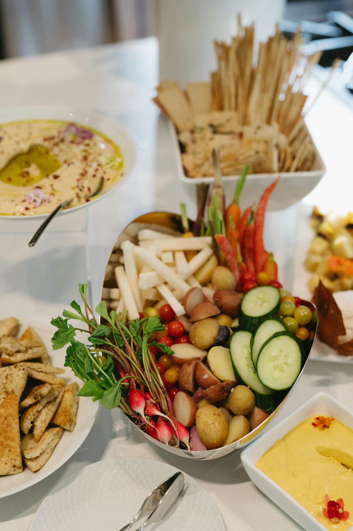 A tablespread of crudites and dips catered by Michelle Bernstein with hummus, breadsticks and cheese.