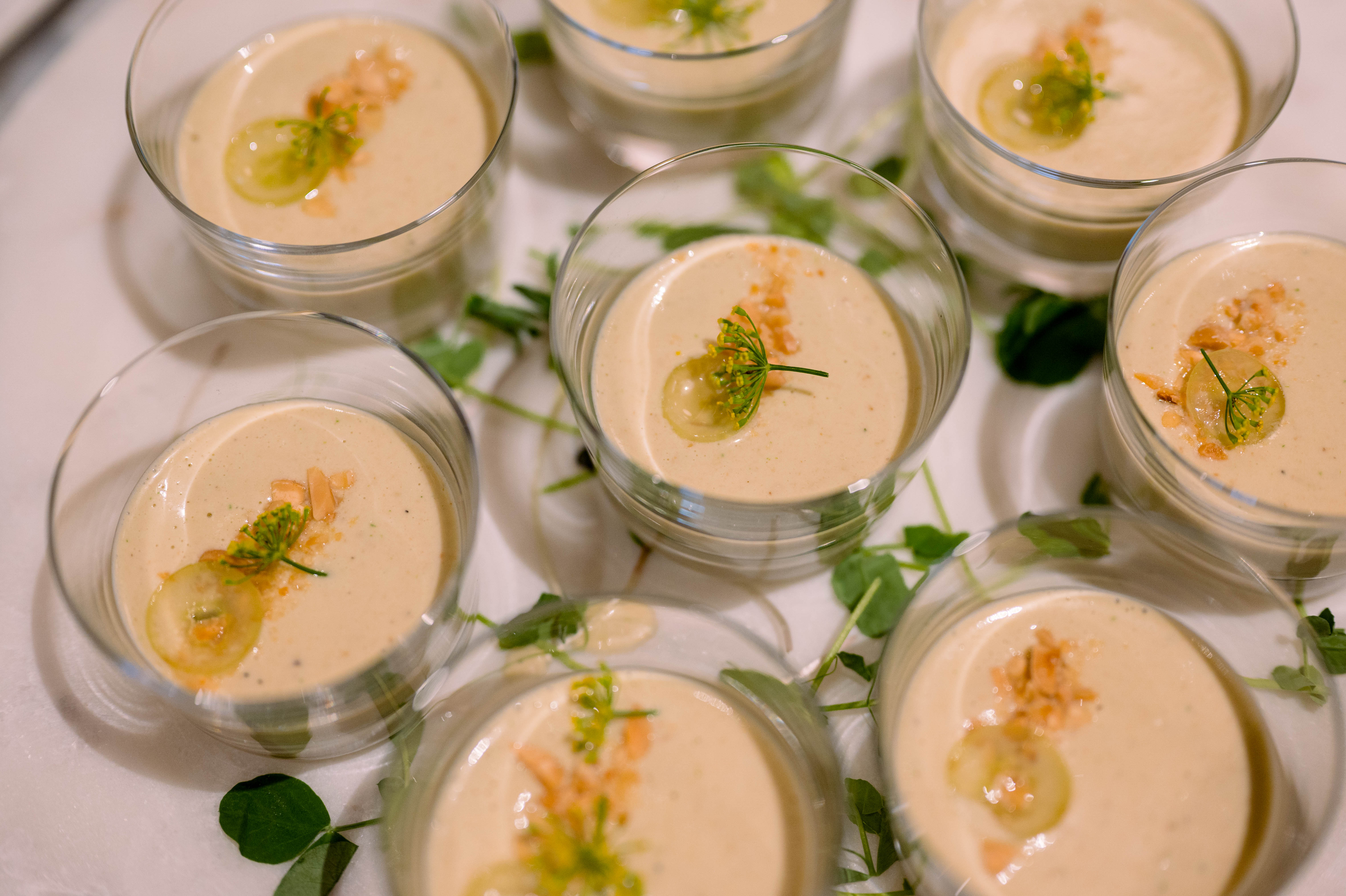 a group of people sitting at a table with a bowl of soup