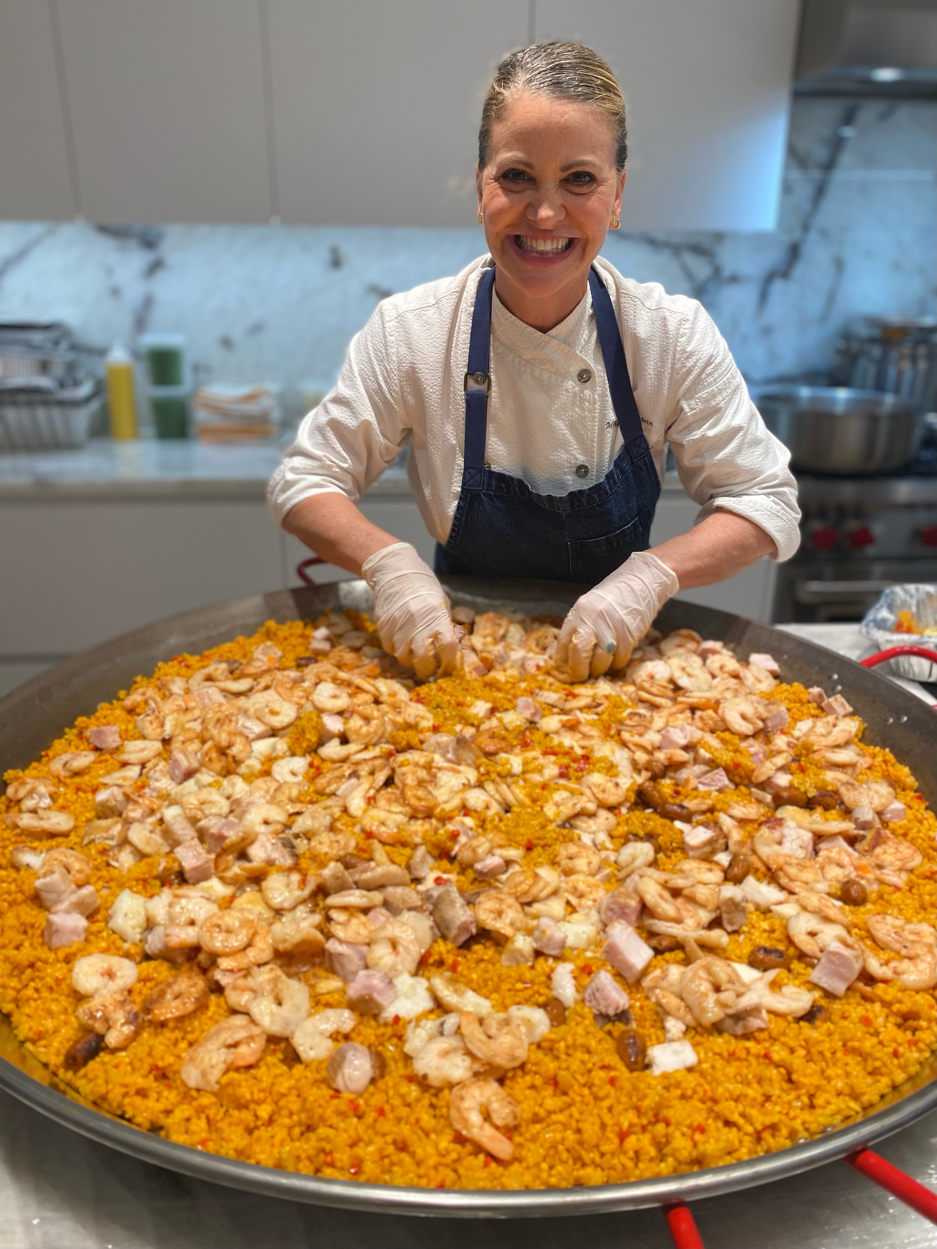 Michelle Bernstein is cutting into a pizza