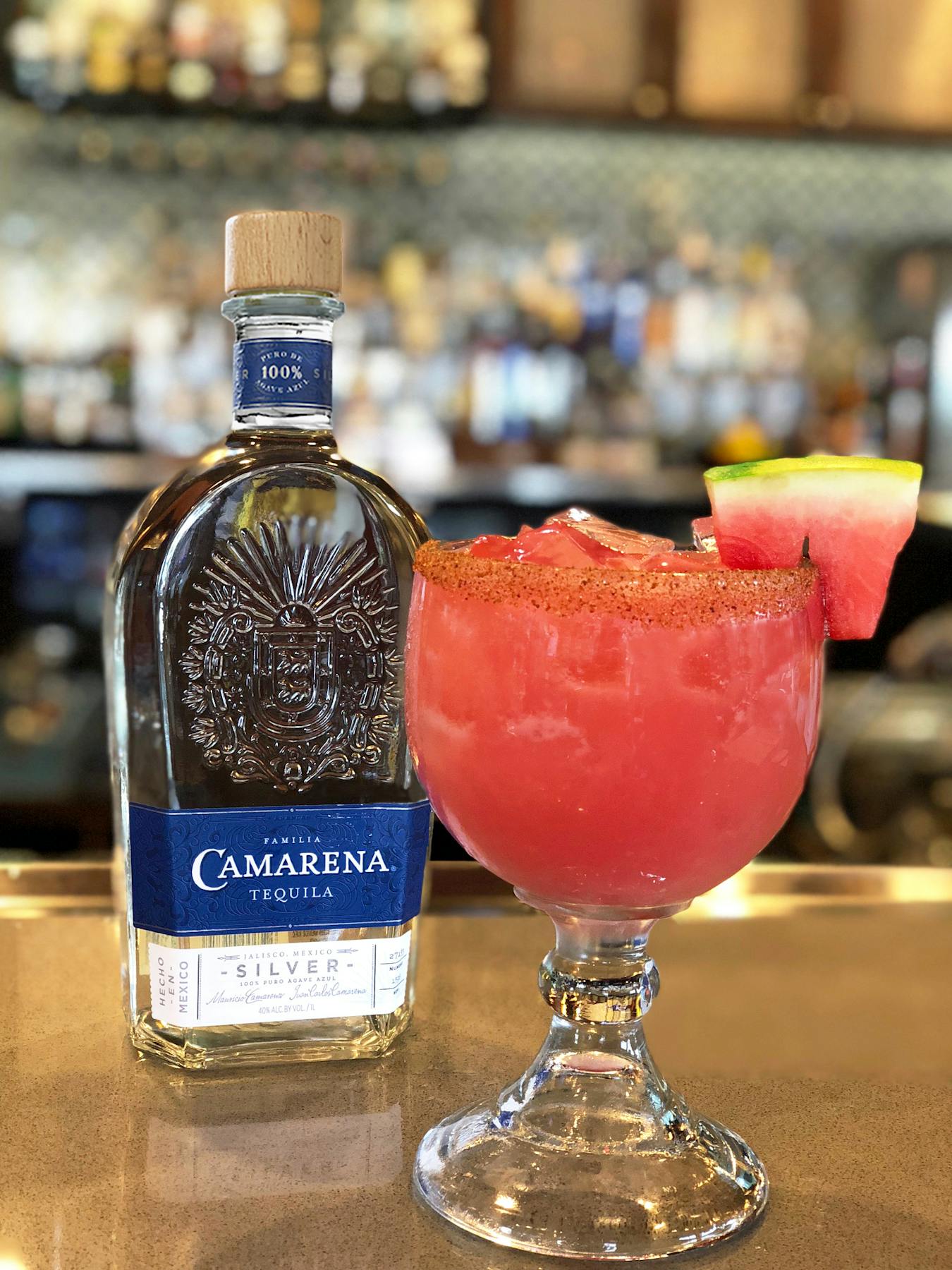 a close up of a vodka bottle and a watermelon cocktail
