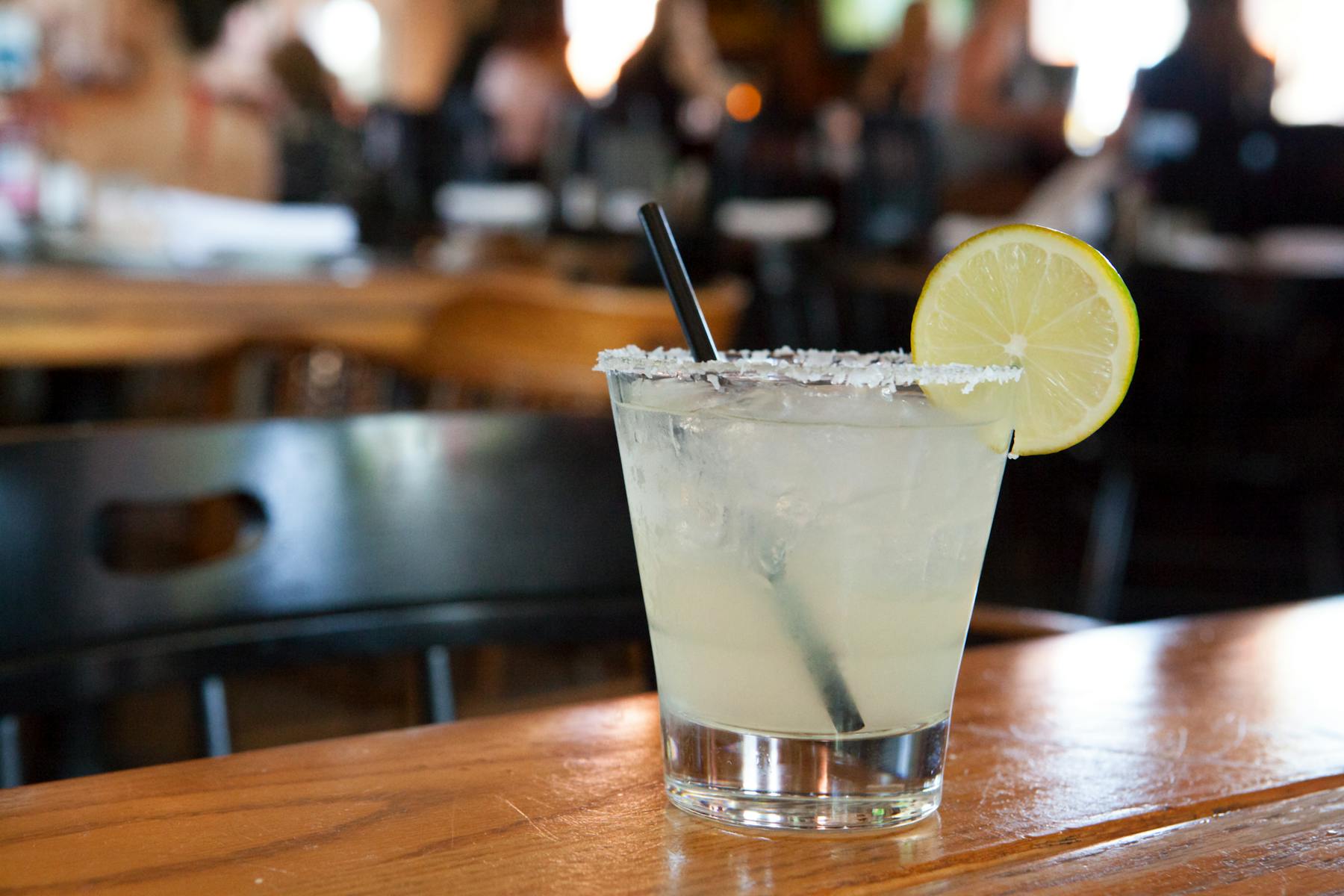 a cocktail sitting on a wooden cutting board