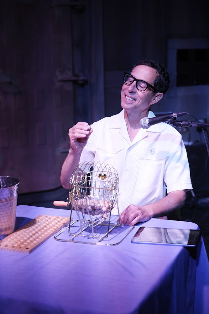 a man sitting at a table with wine glasses