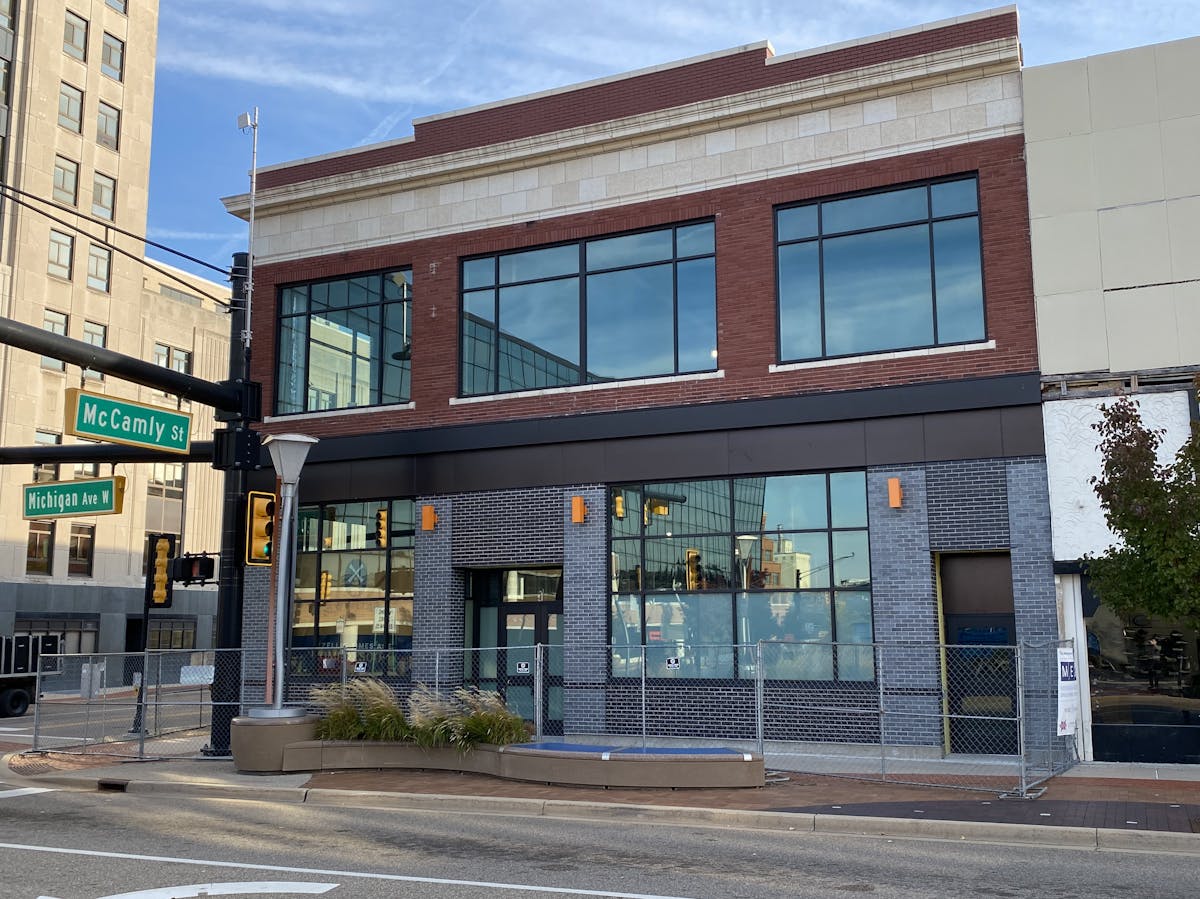 a large brick building with a store on the side of a road