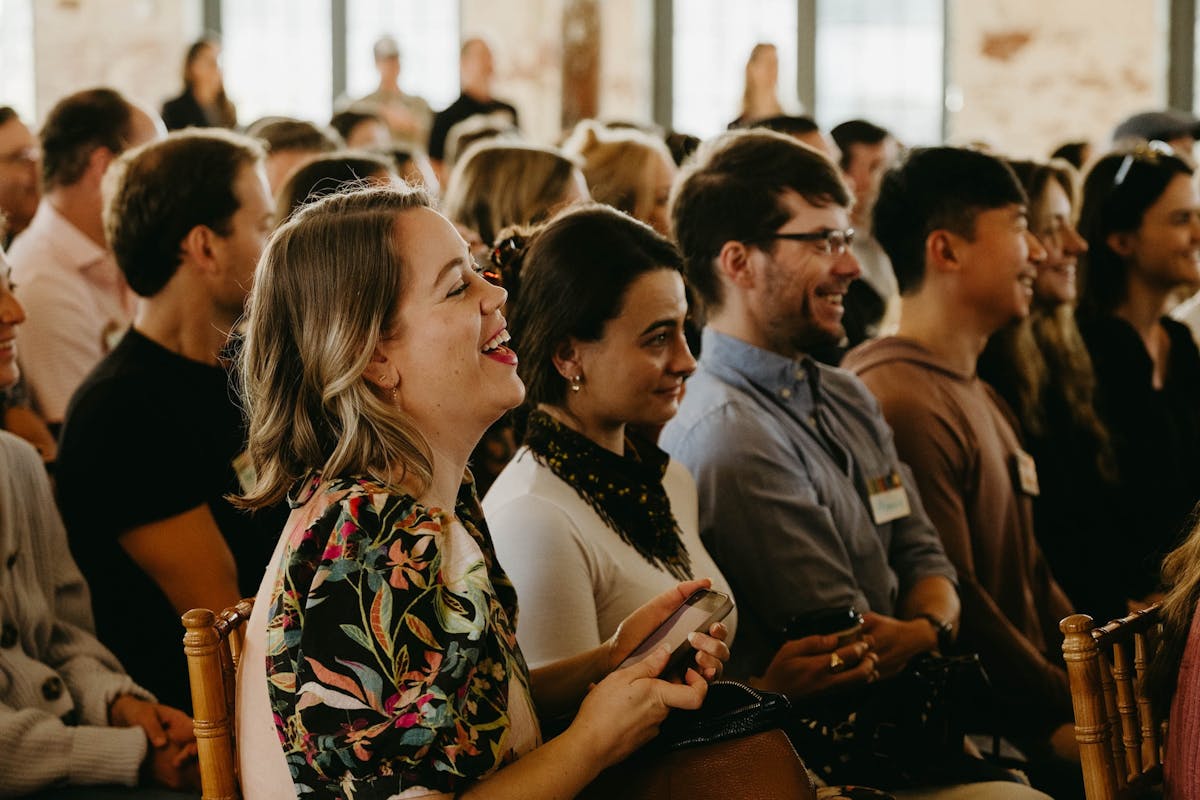 a group of people sitting and standing in front of a crowd