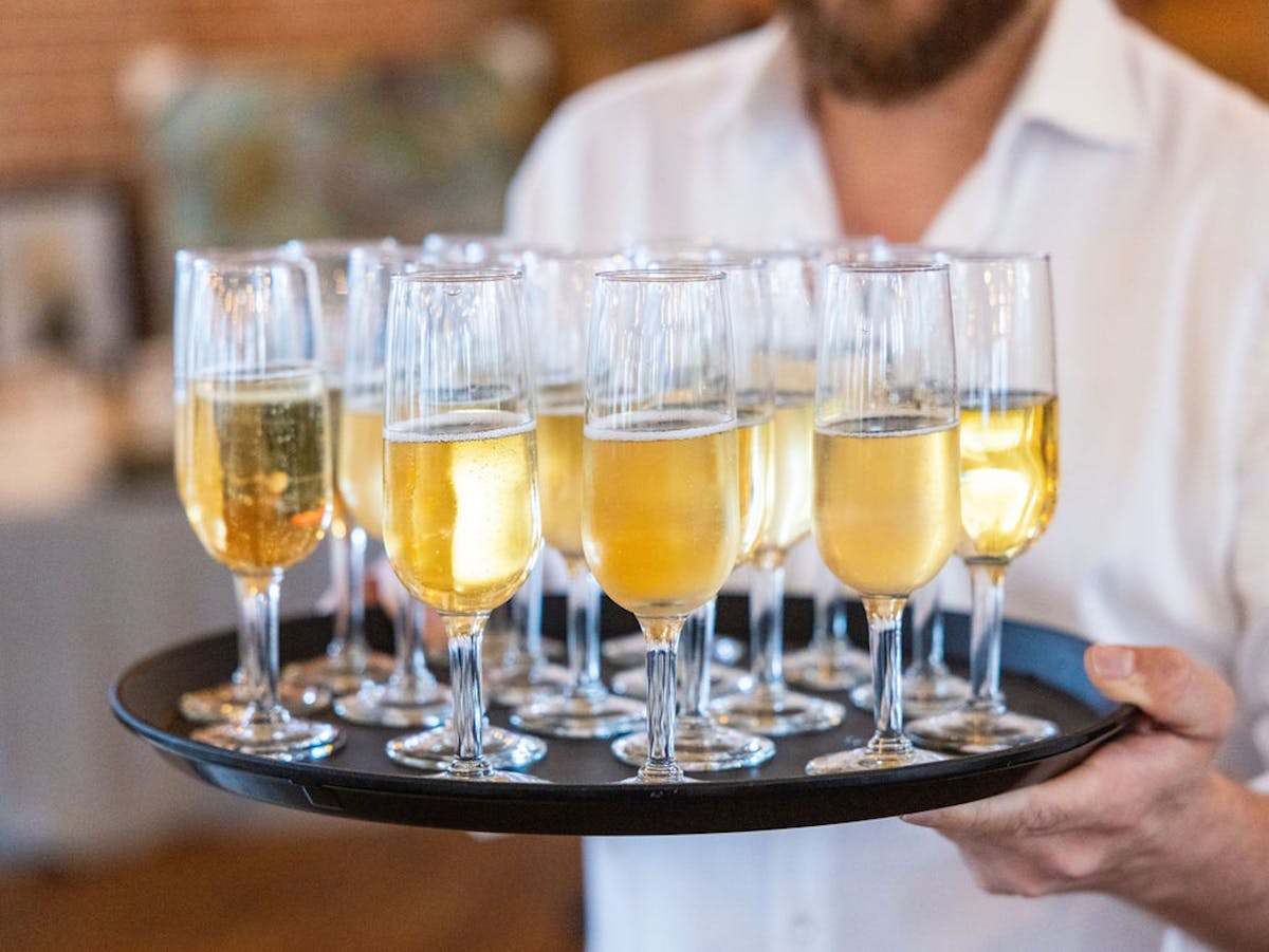 a person sitting at a table with wine glasses
