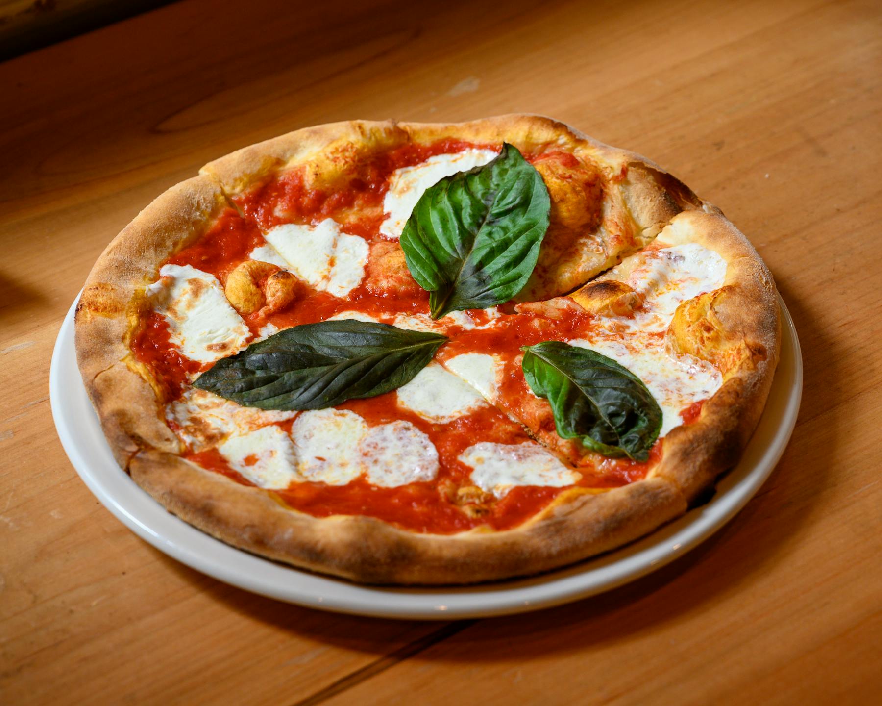 a pizza sitting on top of a wooden table