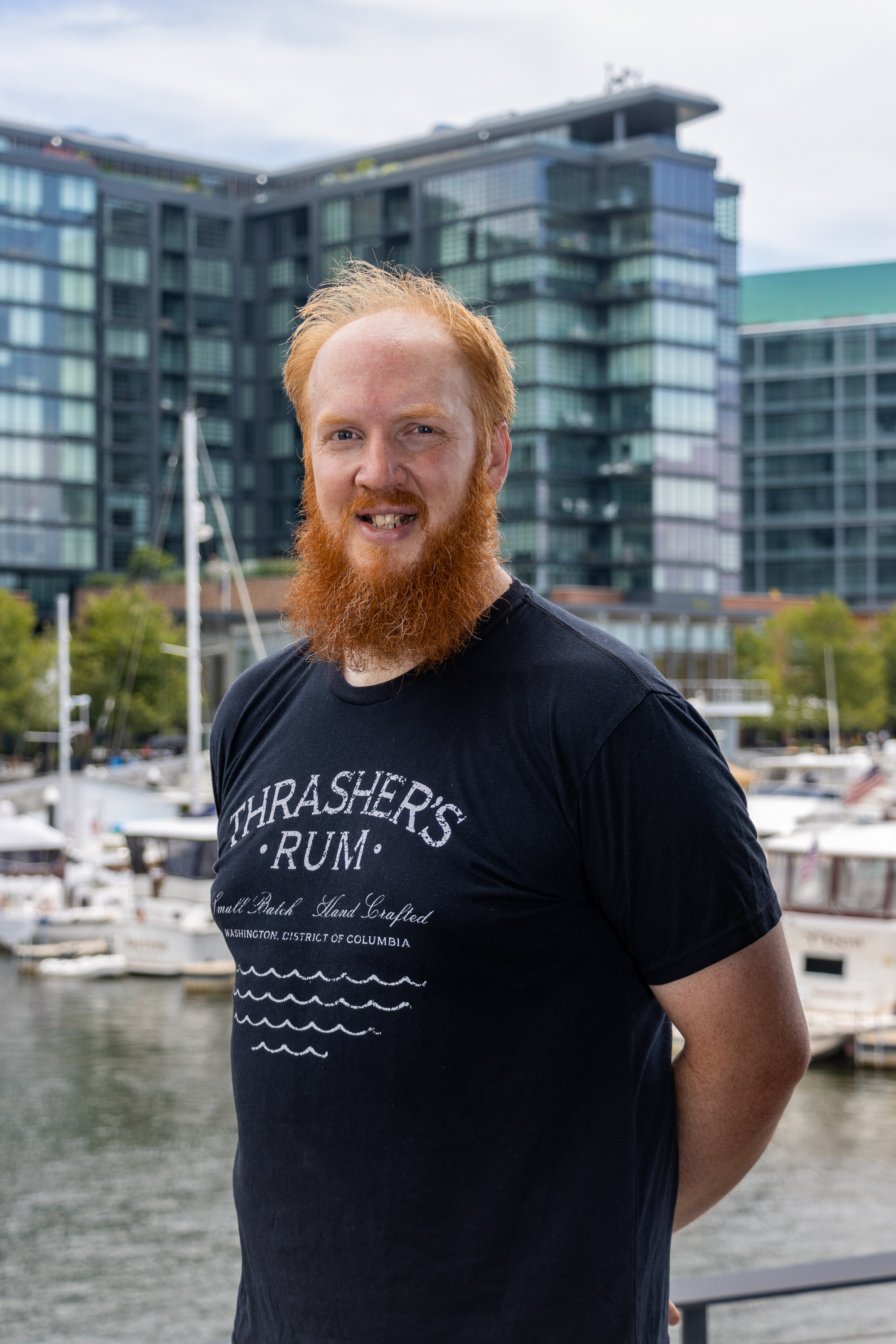 a man with red beard and mustache standing in front of a city