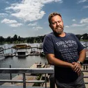 a man standing next to a body of water