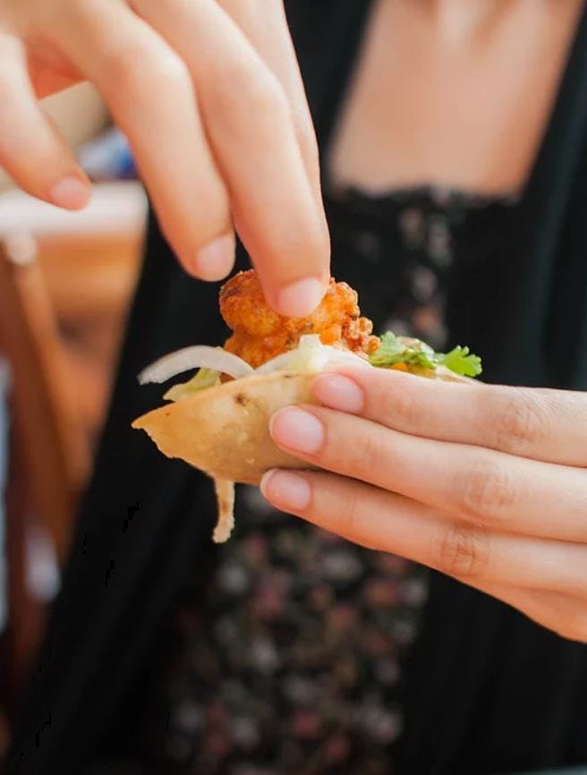 a hand holding a piece of food
