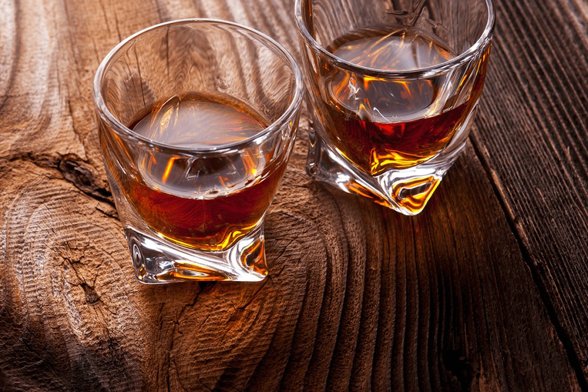 a glass of wine sitting on top of a wooden table