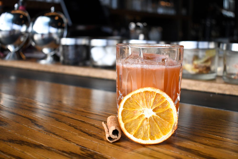 a glass of orange juice on a wooden table