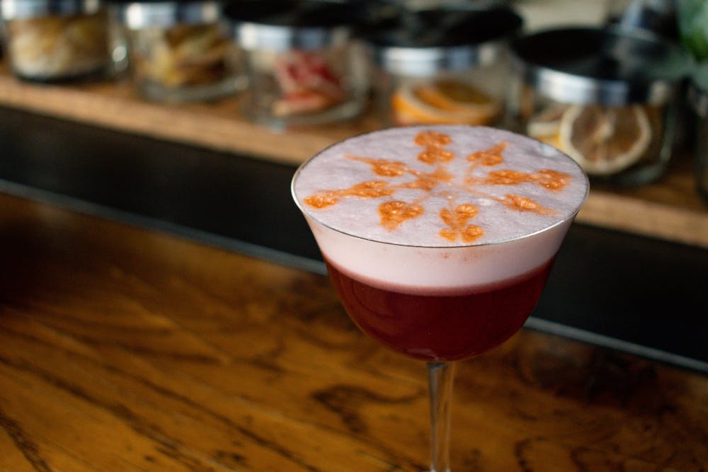a glass of wine sitting on top of a wooden table