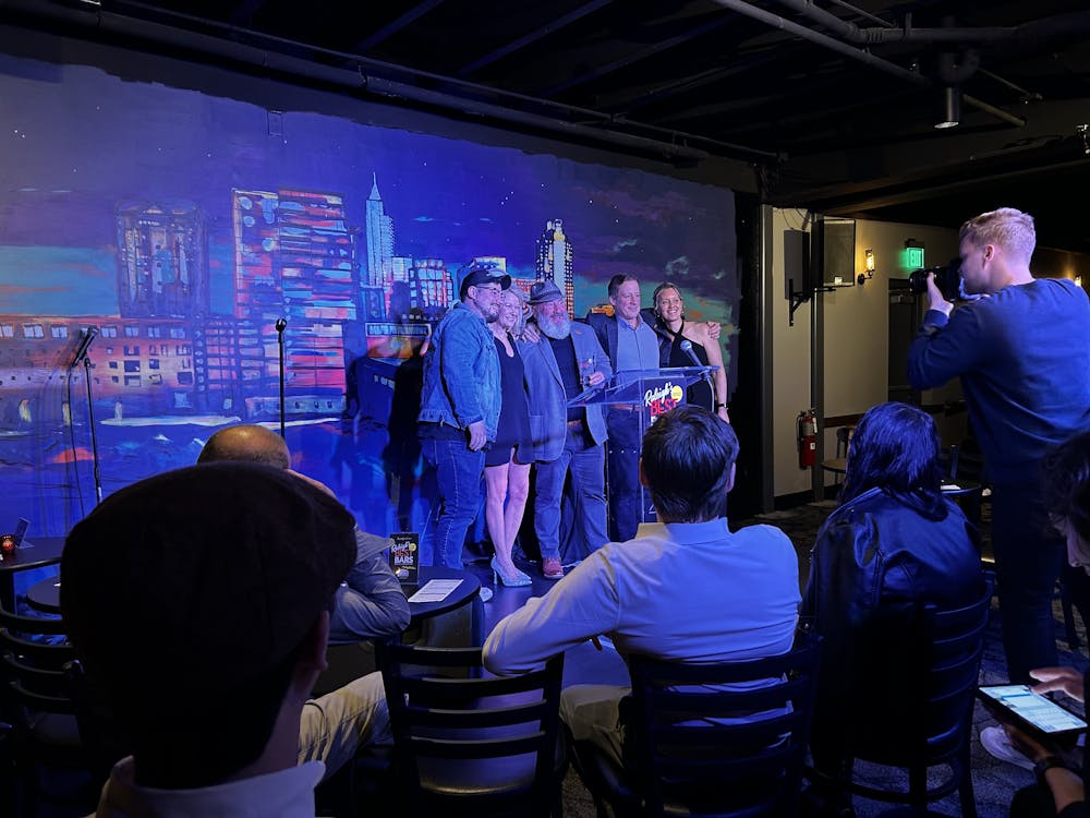 a group of people standing on a stage in front of a crowd
