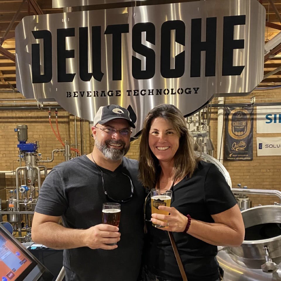 Bryan and Kristen standing in the brewery with a couple beers