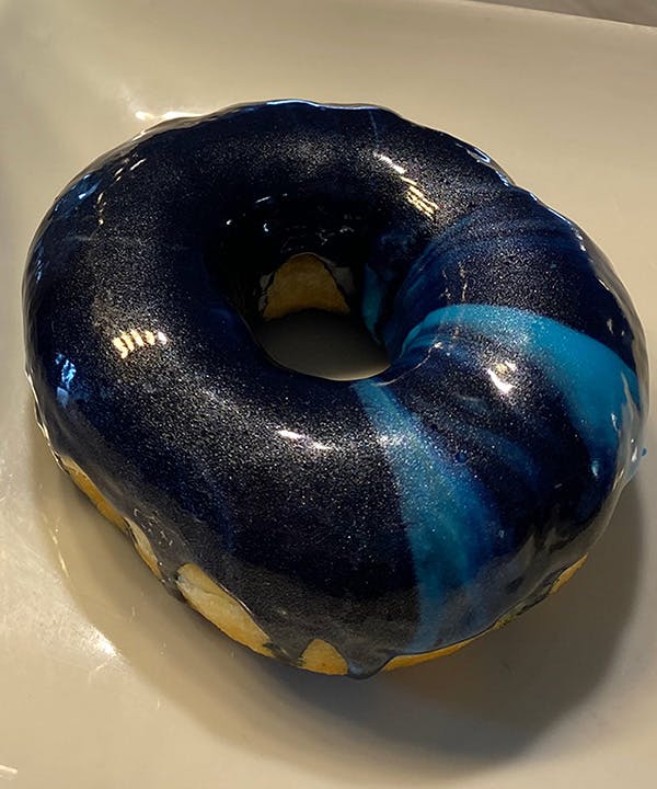 a donut sitting on a blue surface