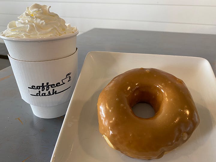 a doughnut sitting next to a cup of coffee