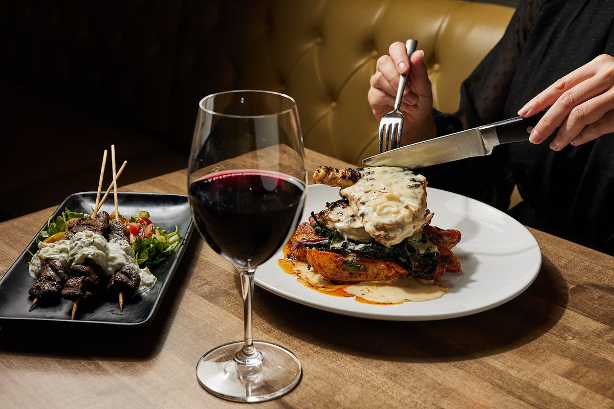 a plate of food with a fork and a glass of wine