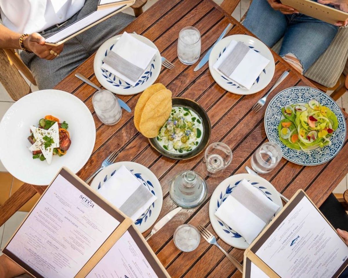 a group of people sitting at a table with a plate of food