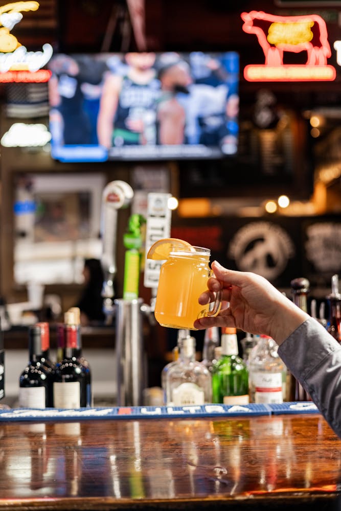 a person holding a bottle of wine on a table