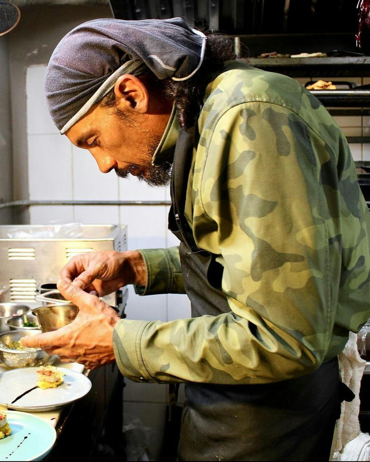 a man cooking in a kitchen preparing food