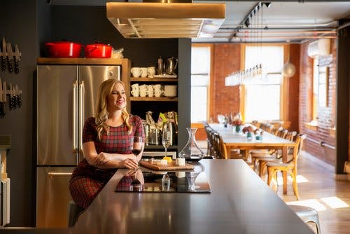 a person sitting at a table in a kitchen