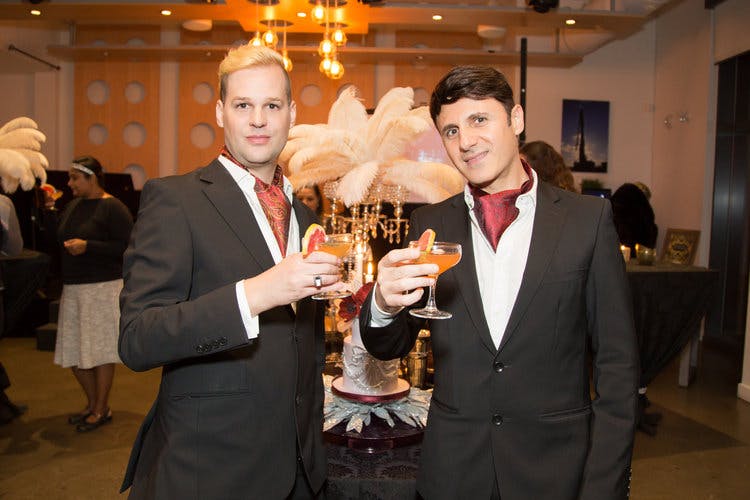 a man wearing a suit and tie holding a wine glass