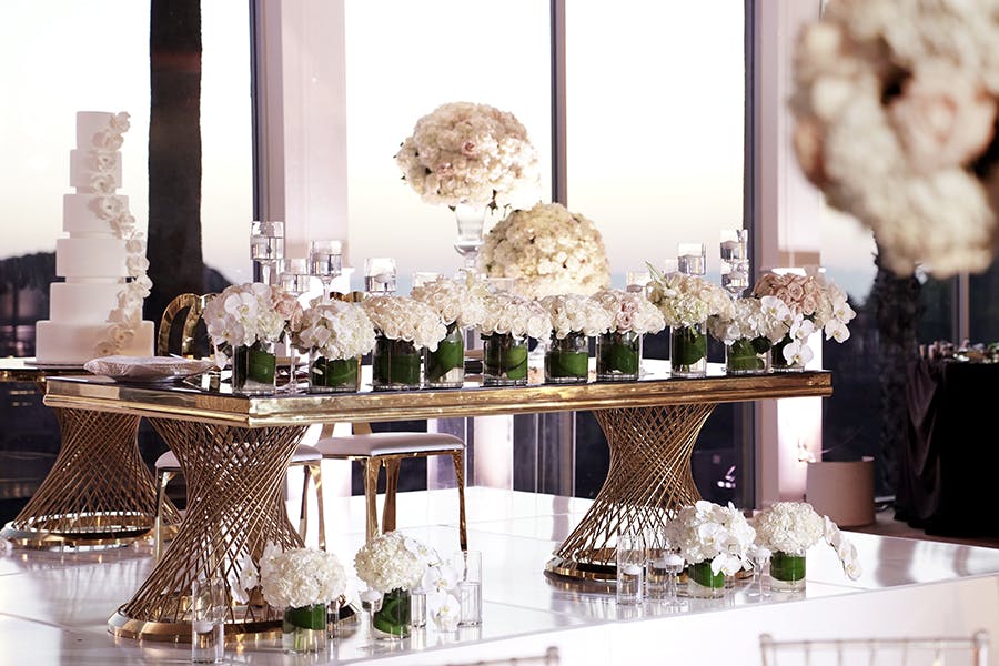 a group of people sitting at a table with a vase of flowers