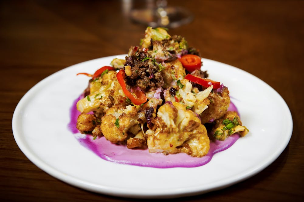 a white plate topped with meat and vegetables