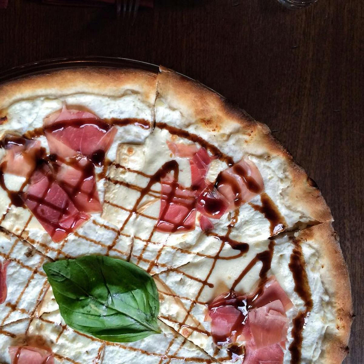 a pizza sitting on top of a wooden cutting board