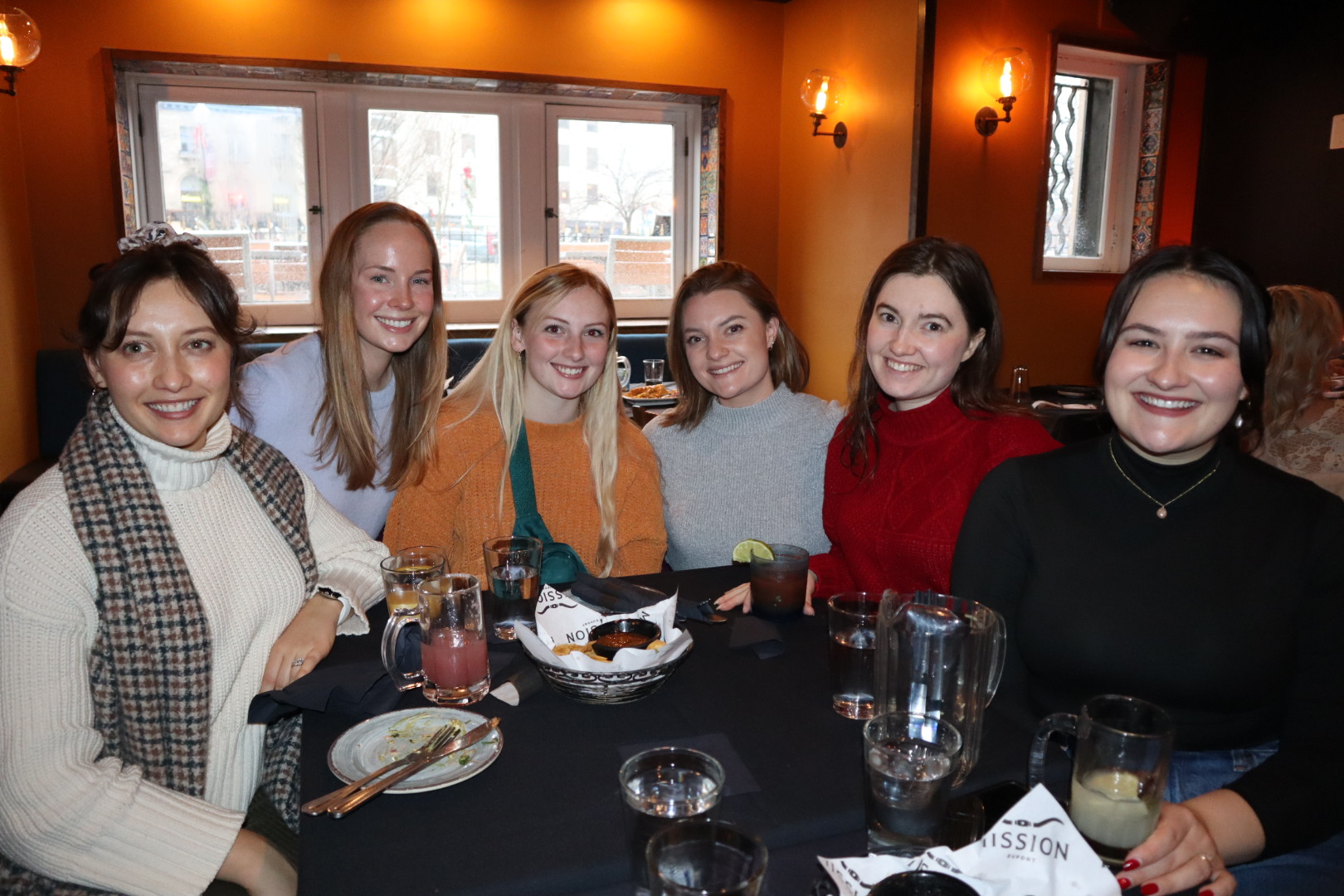 a group of people sitting at a table posing for the camera