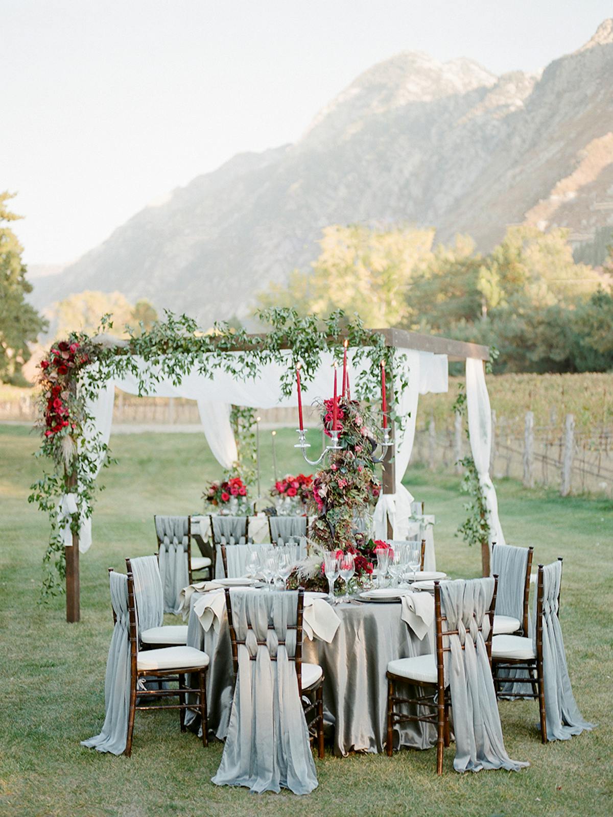 a group of people sitting on a bench in front of a mountain