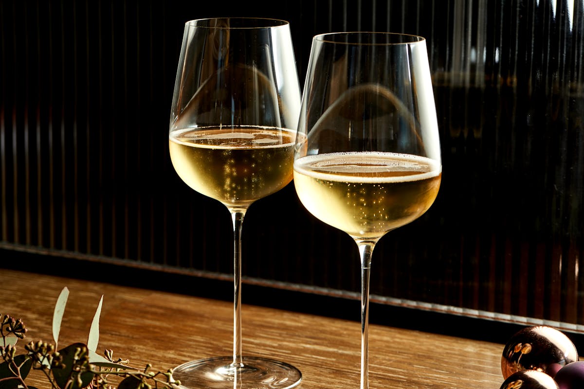 Two glasses of sparkling wine sitting on top of a wooden table