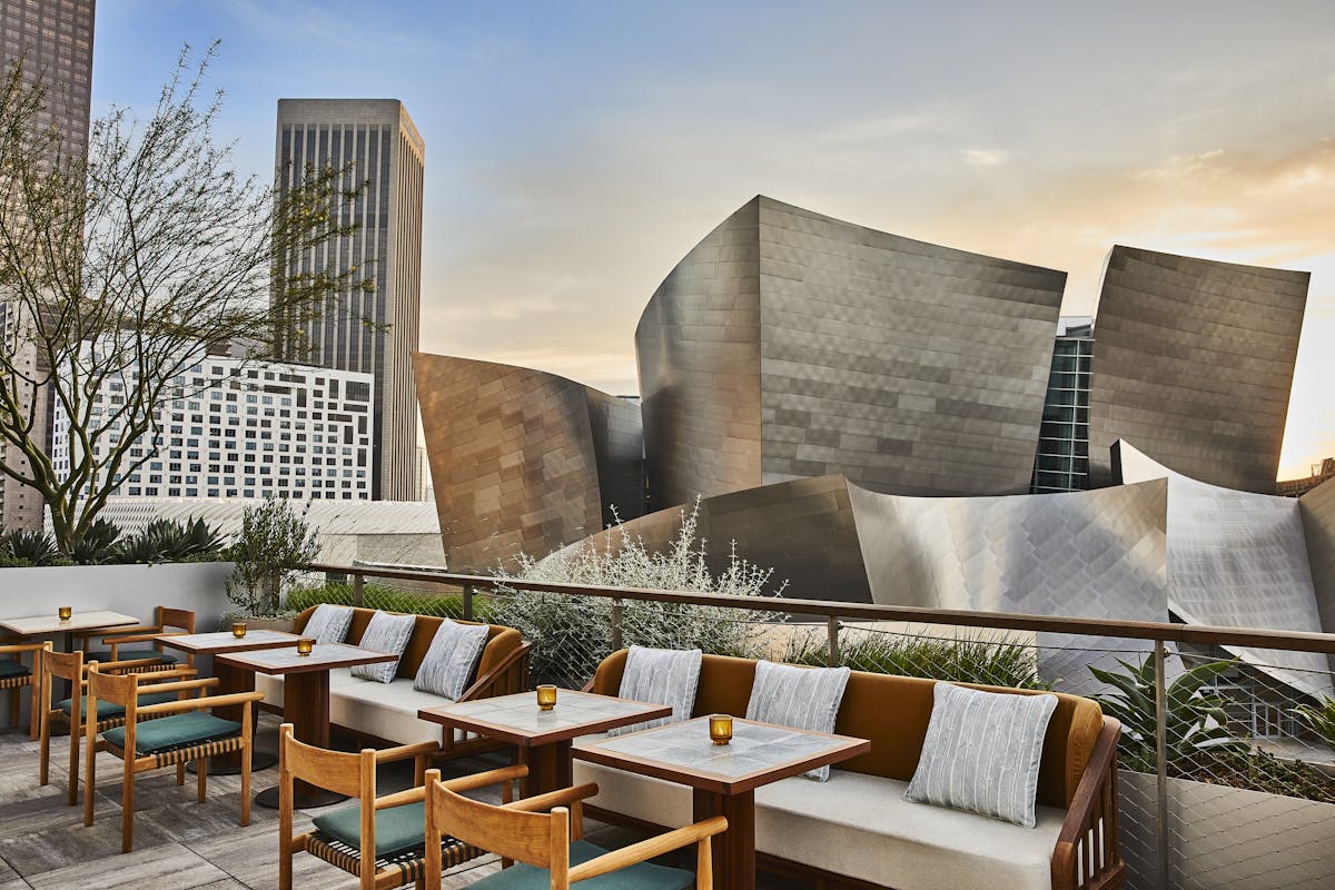 a room filled with furniture and vase on a table with Walt Disney Concert Hall in the background