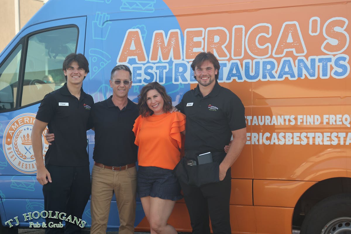 a group of people standing in front of a bus